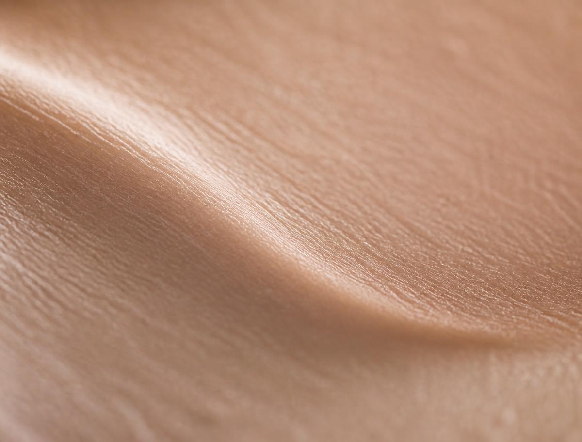 Abstract macro photograph of healthy natural skin texture in warm neutral tones.